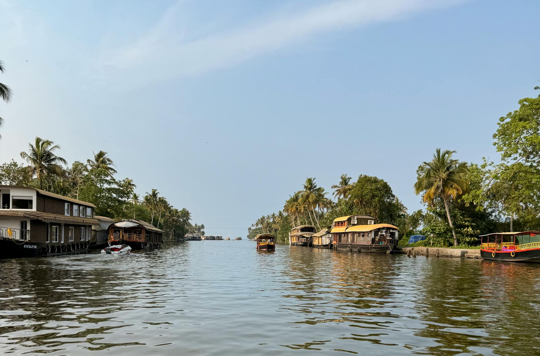 Kerala backwaters — traditional kettuvallam houseboat on palm-fringed waters